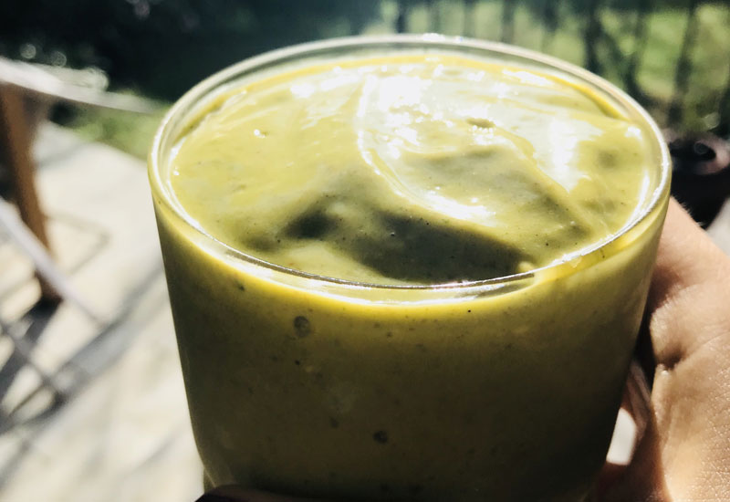 antonia holding a green mango smoothie