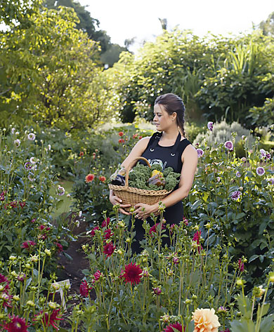 Antonia in her garden holding veggies